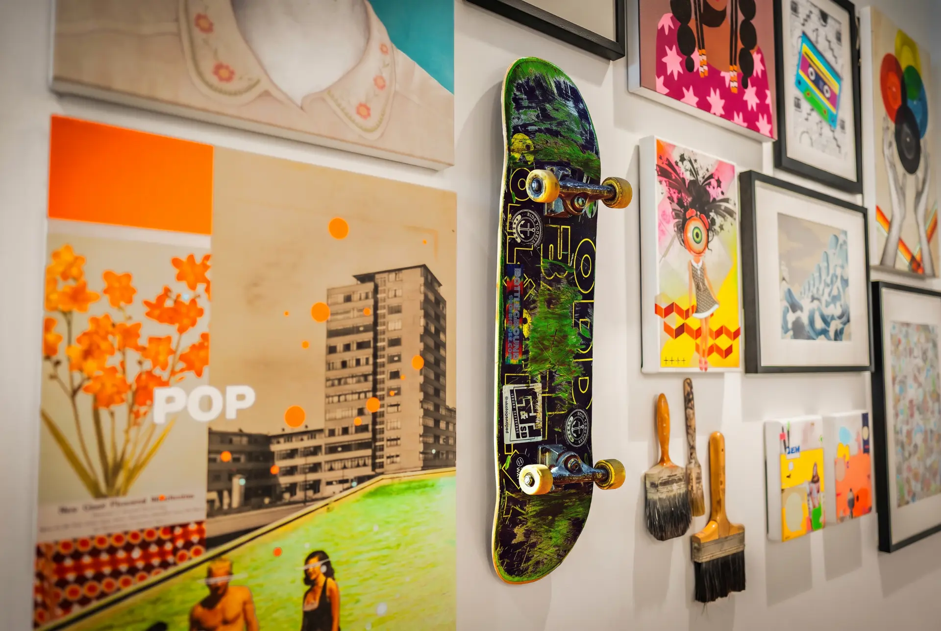 Skateboard mounted on a gallery wall among colourful artwork
